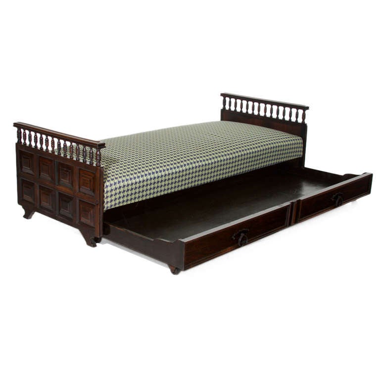 A vintage daybed in solid intricately carved dark stained Mahogany with black and white hounds tooth fabric upholstery. 

Mattress height: 16” 
Total height:  24”

Many pieces are stored in our warehouse, so please click on CONTACT DEALER under