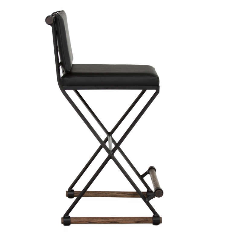 A steel stool with solid oak rounds and leather cushions by Thomas Hayes Studio inspired by the popular designs of Cleo Baldon. The stools are sturdy and comfortable, and has a criss-cross steel pattern on the back. Available in counter height and
