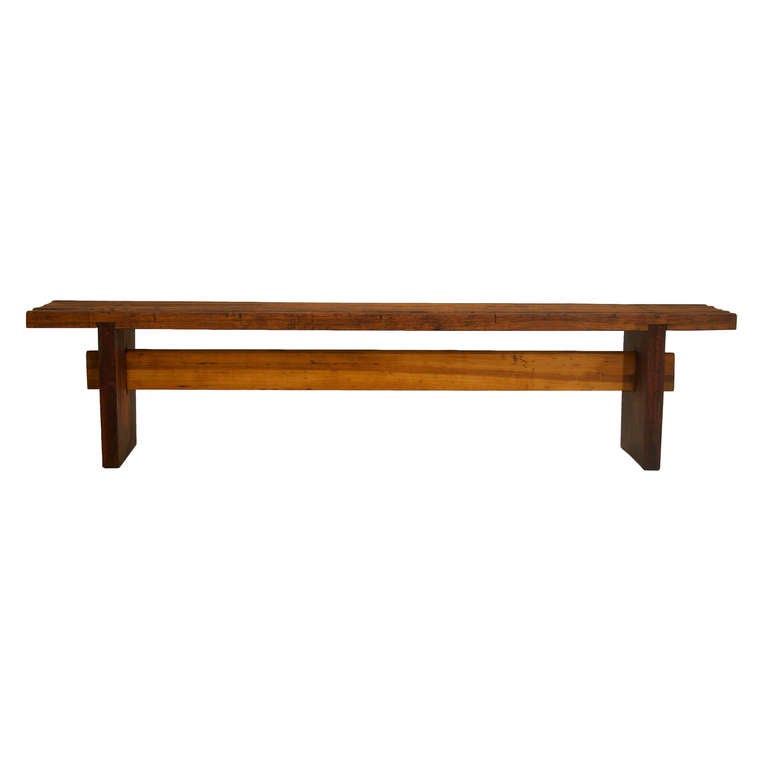 A rare solid Brazilian hardwood bench by Lina Bo Bardi from Brazil with slat top of Peroba de Campos and solid slab feet of Baruna wood. The piece aged nicely outdoors for some years and the hardwood shows cracks and signs of aging that only add to