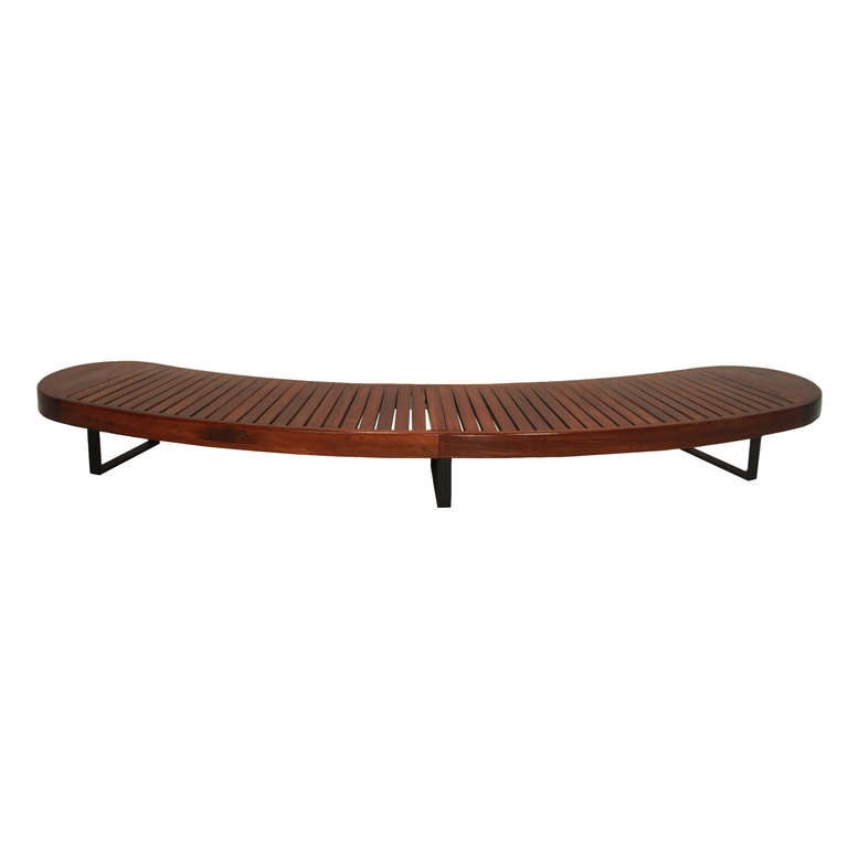 A huge slightly curved bench from Brazil in exotic hardwood with slats long the length and solid flat bar legs. This piece is attributed to Carlo Hauner.

Many pieces are stored in our warehouse, so please click on CONTACT DEALER under our logo