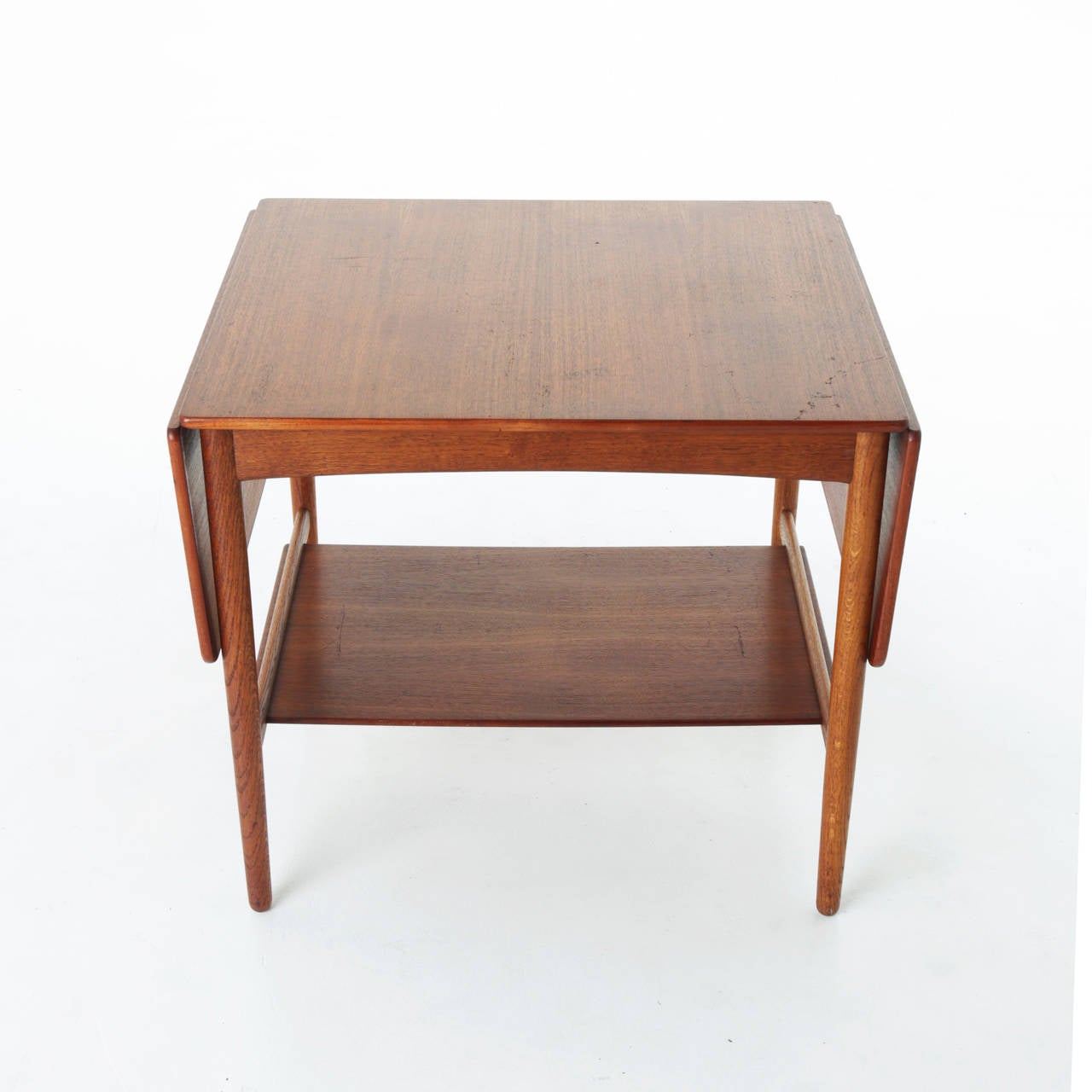 A lovely Danish teak side table with shelf and extendable sides. 
Measures:
With extensions up:
Width: 47.5 inches.
Depth: 23.5 inches.
Height: 24 inches.

Many pieces are stored in our warehouse, so please click on Contact Dealer under our