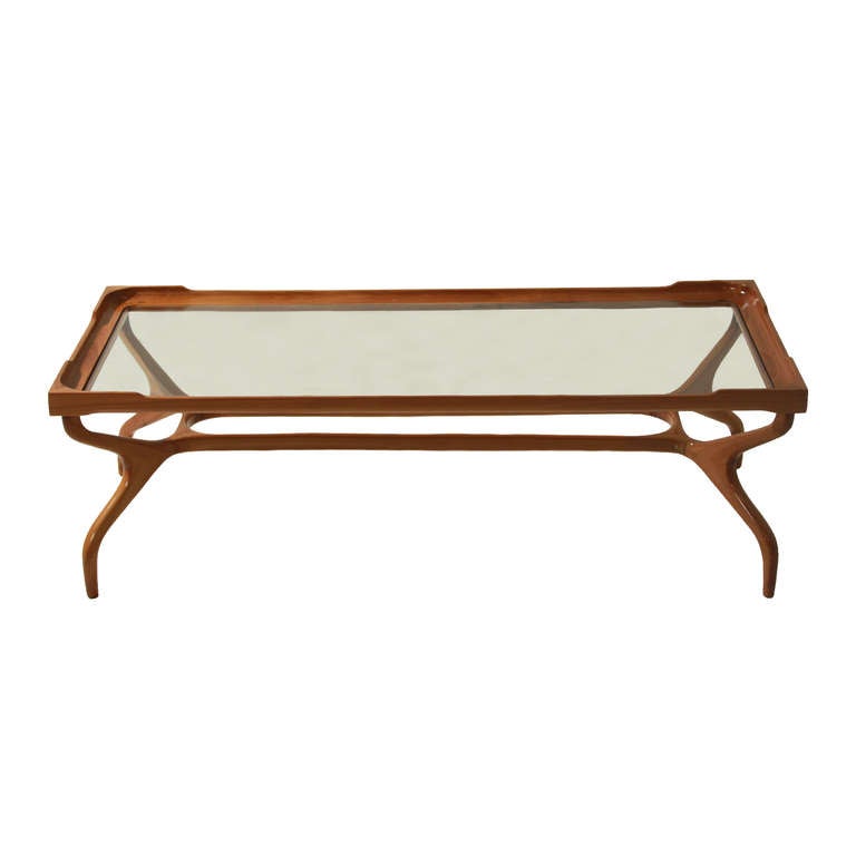 A sculptural glass coffee table by Guiseppi Scapinelli in rich natural solid Peroba de Campos. The legs curve inward, connect, and curve outward while tapering toward the base. It is an obviously Brazilian design but also highly influenced by