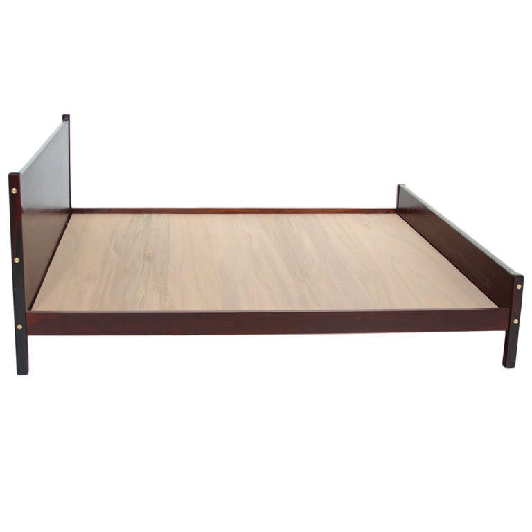 A beautiful Solid Rosewood Bed by Sergio Rodrigues. The bed is a very simple but elegant design. Along the posts there brass brushed plugs.

Additional measurements:

Mattress inset Height: 11