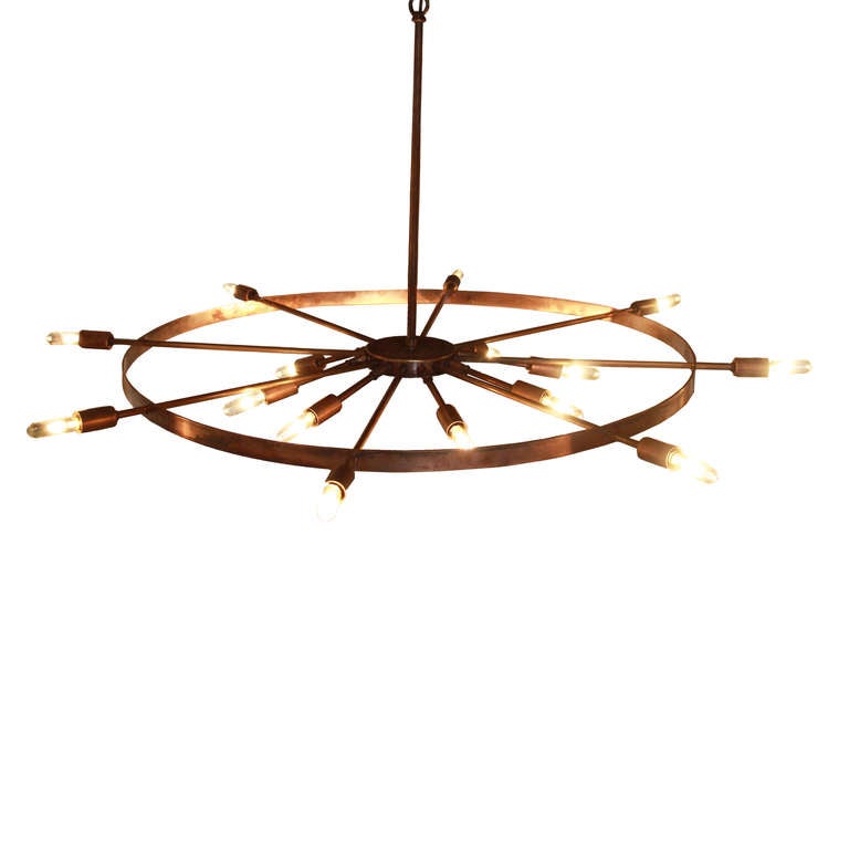 Antiqued brass wheel chandelier with 2 rows of exposed light bulbs by Thomas Hayes Studio available for custom order. The top row of 8 bulbs is affixed to the wheel like spokes and extends beyond, while the second row of 8 are shorter spokes that