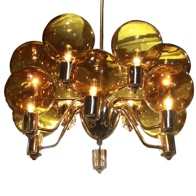 A stunning polished brass chandelier with two rows of six golden glass globes (12 globes total) staggered around the central support.

