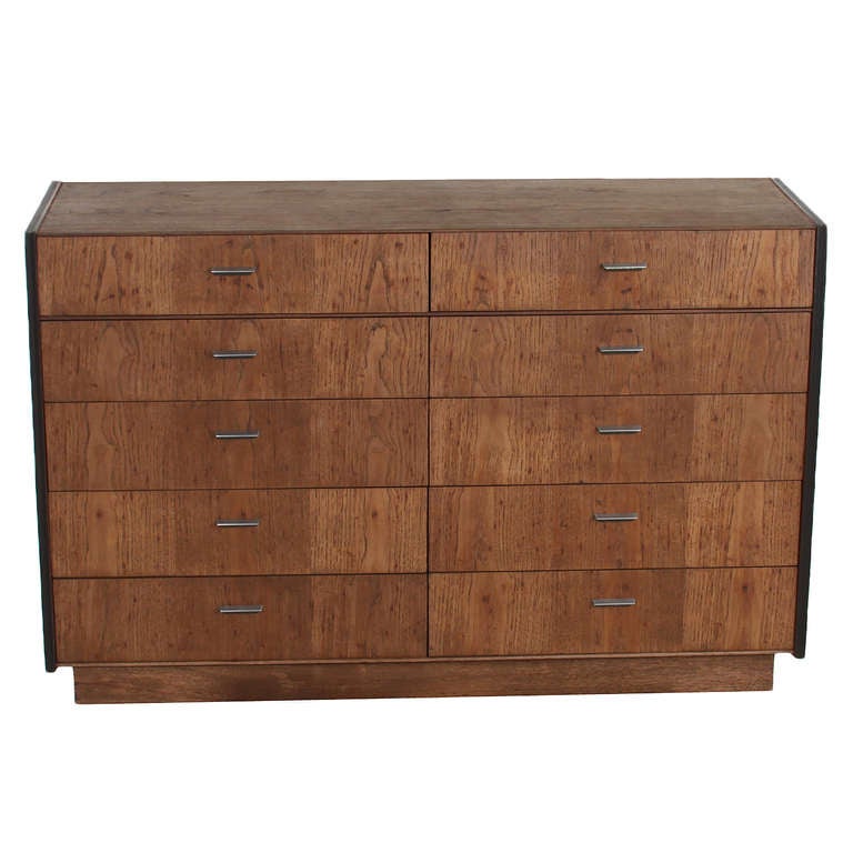 A simple design cabinet in Solid Oak. The cabinet has ten drawers with chrome handles. It is finished in a chocolate oil and has ebonized banding along the beveled case edges.  Possibly manufactured by Glenn Of California.  

Many pieces are