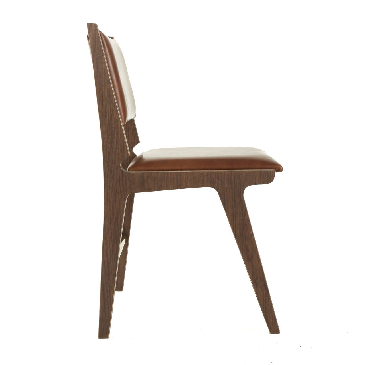 A sculptural dining chair in Baltic Birch plywood available for custom order by Thomas Hayes Studio inspired by the designs of Martin Eisler with comfortable upholstered seat and floating back. The chairs have a beautiful detail at the back of the