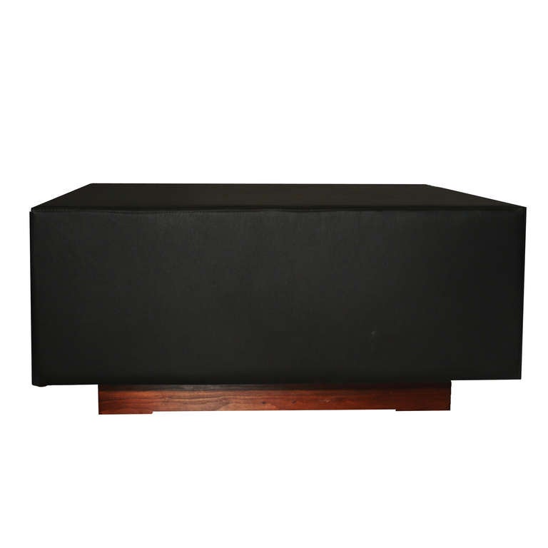A vintage square coffee table wrapped in supple black leather with an inset plinth base in Brazilian Garapa wood by Jorge Zalszupin.

In order to preserve our inventory, after restoration we blanket wrap and store nearly every piece in our