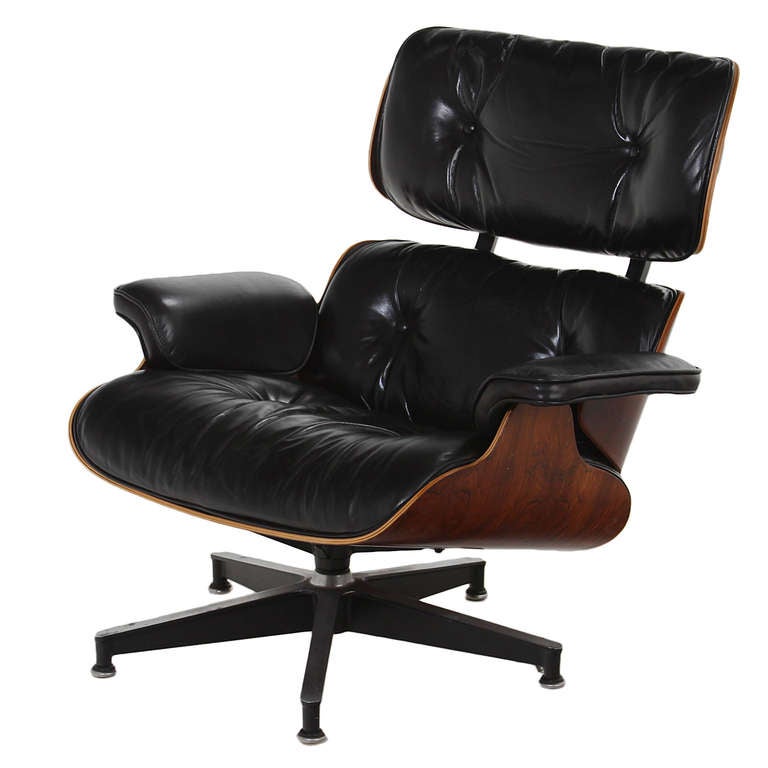 A stunning example of the classic chair and ottoman by Ray and Charles Eames for Herman Miller in Rosewood. This chair is upholstered in black leather that has aged beautifully. Both the chair and ottoman have a Herman Miller label underneath. Shock