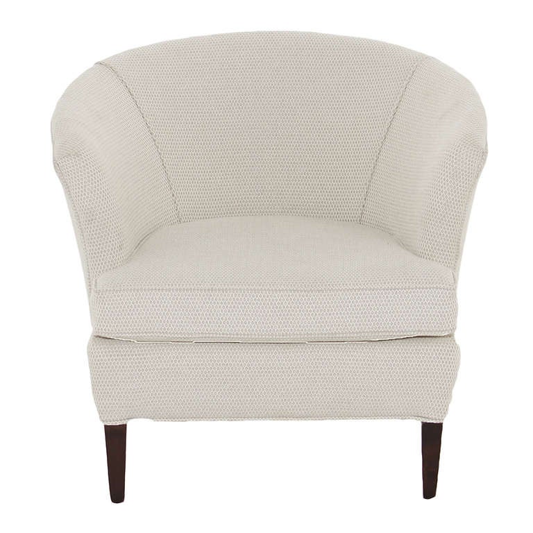 An elegant lounge chair with Solid Walnut legs upholstered in a cream honeycomb fabric. The chair back curves around to the arms in a half circle shape. 

Seat depth: 22