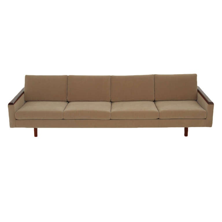 A simply elegant sofa upholstered in a beige suede with solid walnut armrest and legs. This sofa is attributed to Metropolitan. 
Measures:
Seat depth: 22"

   