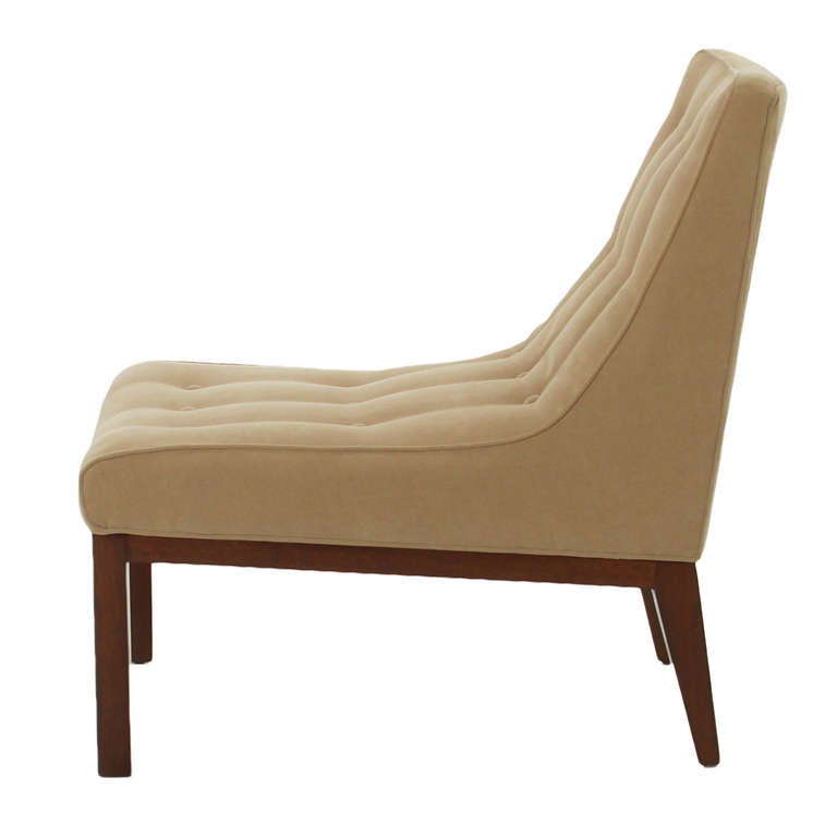 A single midcentury slipper chair with refinished solid Mahogany base and reupholstered in button-tufted tan fabric with piping by Dunbar. 

Seat Depth 21