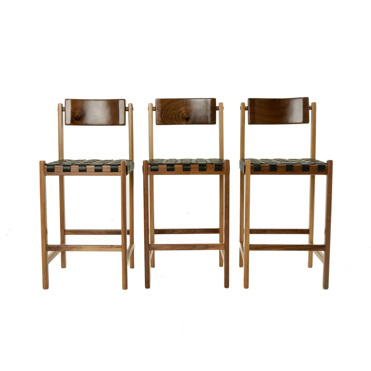 A sturdy solid walnut bar stool with a seat of woven leather straps and back of carved solid walnut that pivots for ultimate comfort. The frame has polished brass details on the sides.

Available for custom order and the lead time is 8-12 weeks;