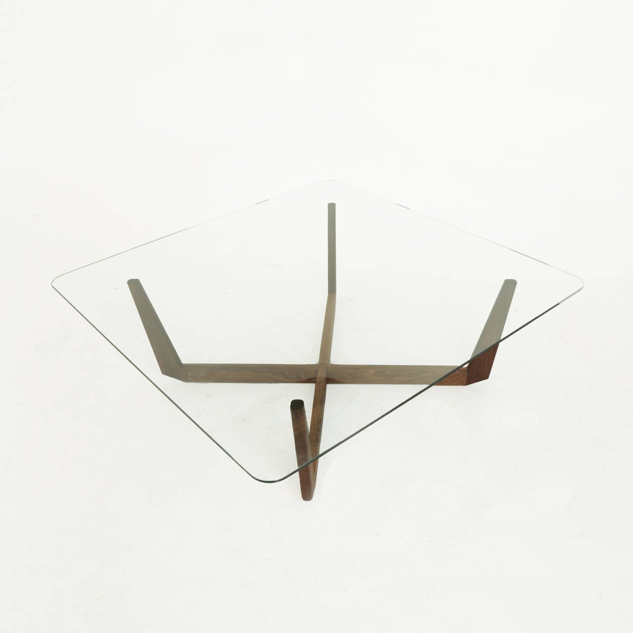 A solid Walnut sculptural base coffee table supporting a square glass top. The size of the glass top can be changed if needed, and this table comes in square and rectangular sizing. 

This item is available for custom order and the lead time is