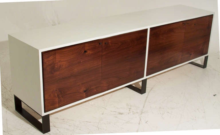 A white leather wrapped credenza with doors of vintage salvaged Caviuna from Brazil and dark bronze finished metal legs. 

Many pieces are stored in our warehouse, so please contact us to find out if the pieces you are interested in seeing are on