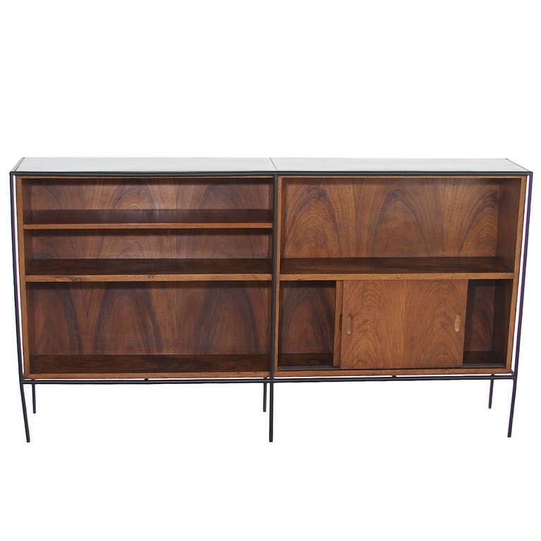 A unique book shelf designed by Brazilian designer Geraldo de Barros in exotic hardwood with black iron tube frame and black Formica top in two sections.

Many pieces are stored in our warehouse, so please click on contact dealer under our logo