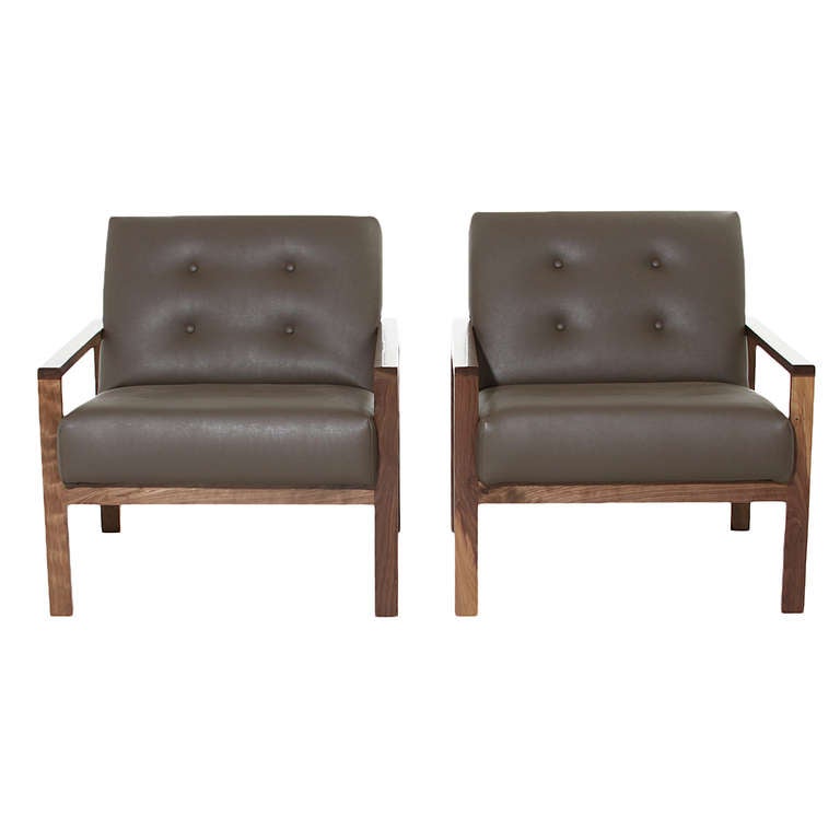 A pair of sturdy and comfortable solid Walnut lounge chairs/armchairs by Thomas Hayes Studio. Arm height is 19