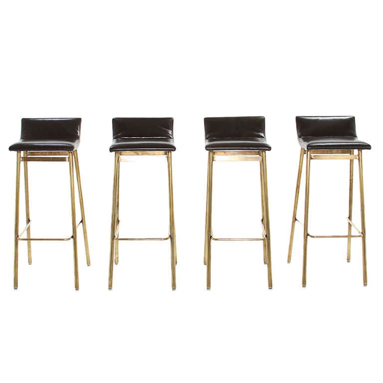 Custom order brass stools with curved leather seats by Thomas Hayes Studio. These stools are sturdy and comfortable and are available with a tufted seat or with a single seam as shown in these photos. The legs are capped with adjustable chrome