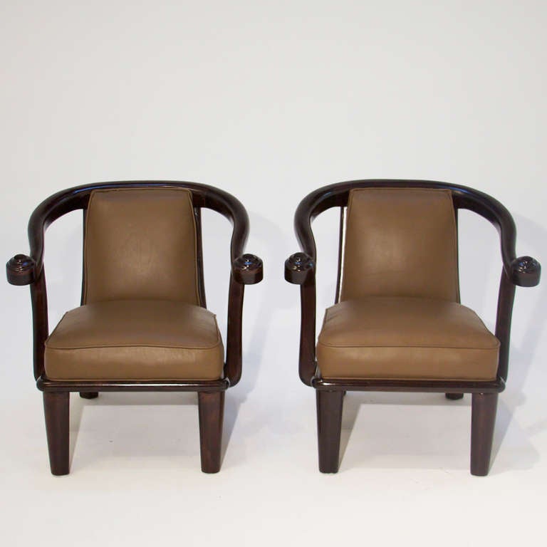 A pair of vintage mahogany arm chairs with scroll shaped arms, curved and sculpted frame, upholstered in an olive green leather. A second pair is also available that has not been restored, so it is available COM (customer's own