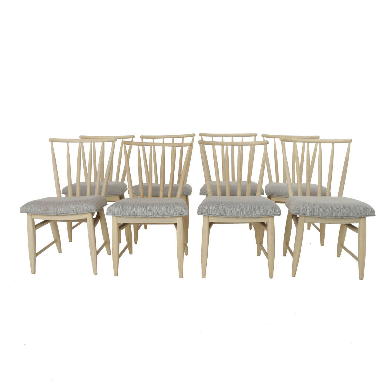 A lovely set of eight spindle back dining chairs in bleached wood with oil finish and upholstered in a patterned gray and cream fabric. 

In order to preserve our inventory, after restoration we blanket wrap and store nearly every piece in our