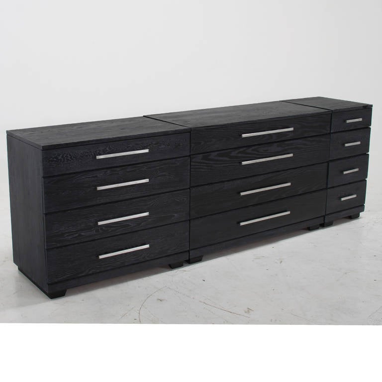 A set of three ebonized Oak dressers by Mengel with wide chrome drawer pulls that can be placed side by side as in the pictures or can be separated as desired. The finish is original and shows some minor wear and blemishes but is overall quite