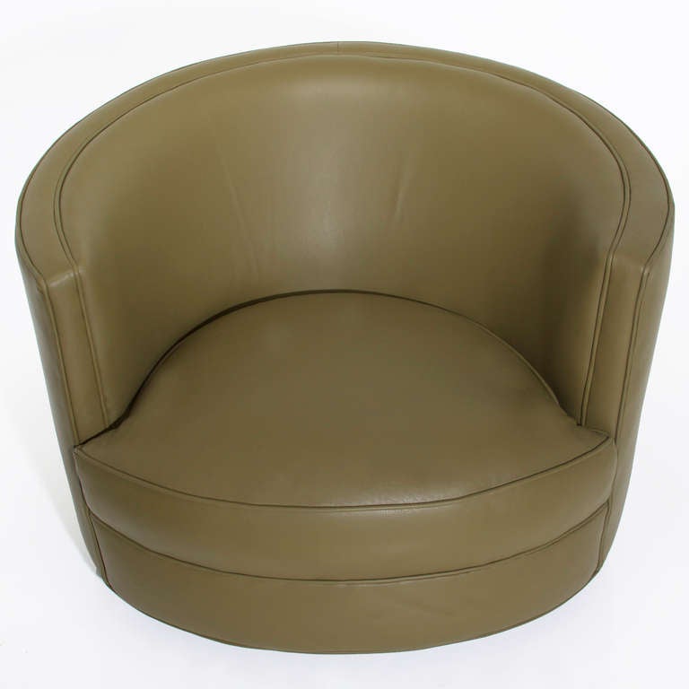 A very comfortable pair of barrel shaped arm chairs that swivel in a rich olive green leather. 

Seat depth measures 23.5