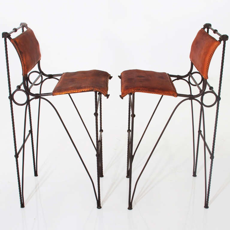 Pair of stunning all original bar stools by Ilana Goor with iron frames and burnt orange leather with sewn edges. Awesome. 

 Seat depth measures 18.5