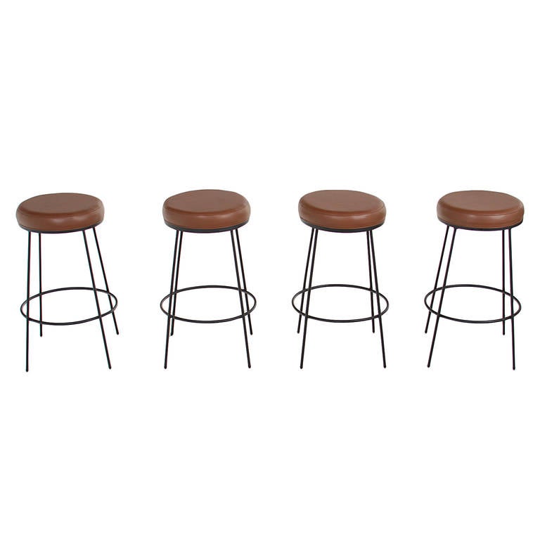 Flat black finished steel bar stools with round upholstered swiveling seats by Thomas Hayes Studio. 

This item is available for custom order and the lead time is 6-10 weeks; sometimes we are able to complete projects faster, so please contact us