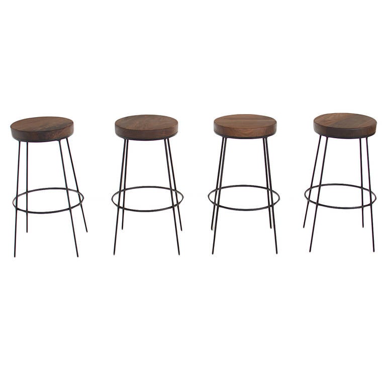 Flat black finished steel bar stools with solid round Walnut swiveling seats by Thomas Hayes Studio. 

This item is available for custom order and the lead time is 6-10 weeks; sometimes we are able to complete projects faster, so please contact us