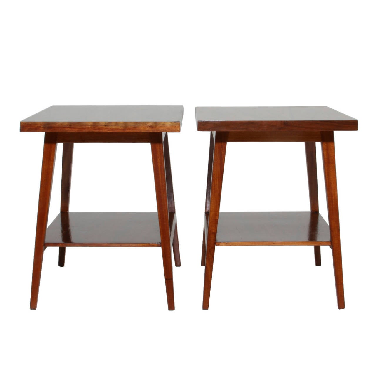 Pair of side tables or nightstands from Brazil. Made from solid rosewood and newly refinished, these tables feature a lower shelf and tapered leg design.

 