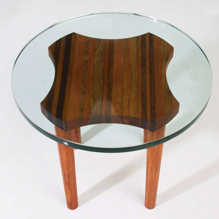 Exotic Brazilian hardwood side tables from designer Rodrigo Calixto's Residuos series with round glass tops. Each base has been created using blocks of solid stack laminated wood. These tables require no nails or screws but a high degree of