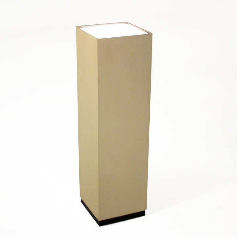 An illuminated vintage flat whote sculpture or display stand designed by Bill Curry for Design Line. The base is a recessed black finished plinth base, and the top features inset frosted glass with light underneath.  White is flat and has a