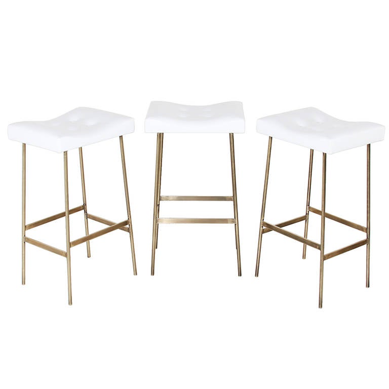 A custom version of the bunda stool by Thomas Hayes Studio with solid brass frames and upholstered tufted leather seat cushions. 

Please look at all pictures, as these stools are individually handmade and the solid brass has some variation. The