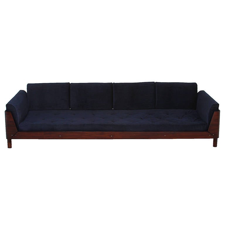 A Rosewood sofa with a spine back detail by Jorge Zalszupin for L'atelier. It is made with curved Rosewood cases and extruded spines as a back rest support. The cushions are upholstered in a blue mohair with tufted seats. 

Many pieces are stored