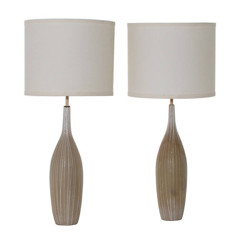 A pair of shapely ceramic lamps in a natural beige with white painted vertical stripes.

Many pieces are stored in our warehouse, so please click on CONTACT DEALER under our logo below to find out if the pieces you are interested in seeing are on
