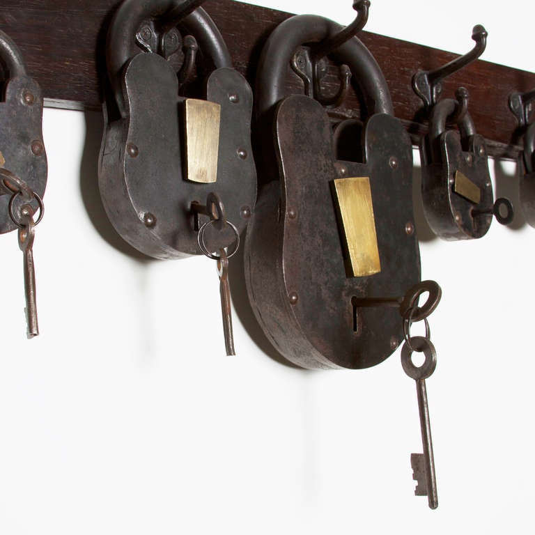 A set of vintage Iron & Brass locks in a variety of sizes displayed on a solid Rosewood panel. A second set with 4 different types of hardware is also available and sold separately. The locks are heavy substantial pieces, the largest lock is close