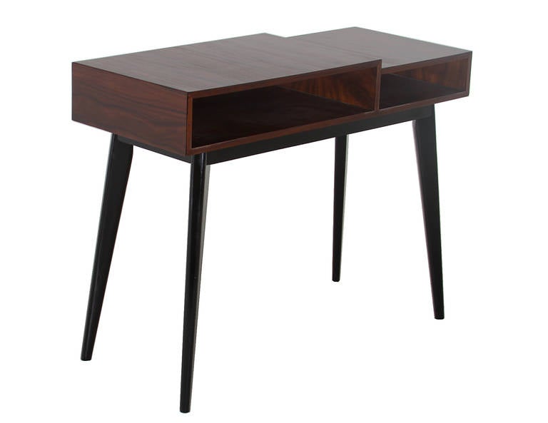 An elegant console from Brazil. The top portion has two tiers that are different sizes, they both have an open shelf for storage. The base has four legs that splay outwards and have been finished in a ebonized satin lacquer.

