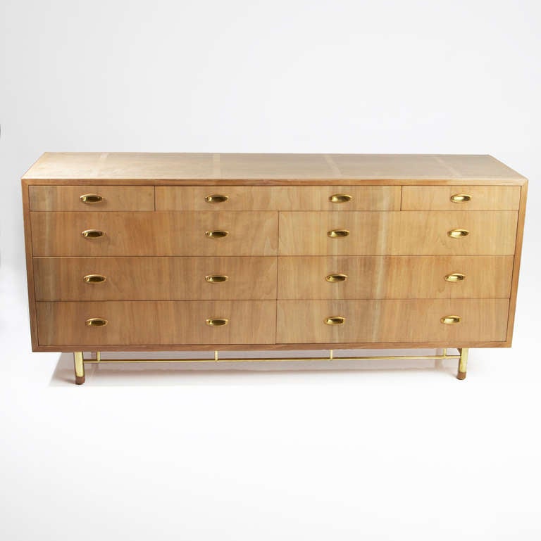 A vintage bleached Walnut dresser with brass base and solid brass hardware inlays. The dresser has 6 large drawers with a top level of 3 smaller drawers. The Walnut grain is beautifully enhanced by the bleached finish and the polished brass
