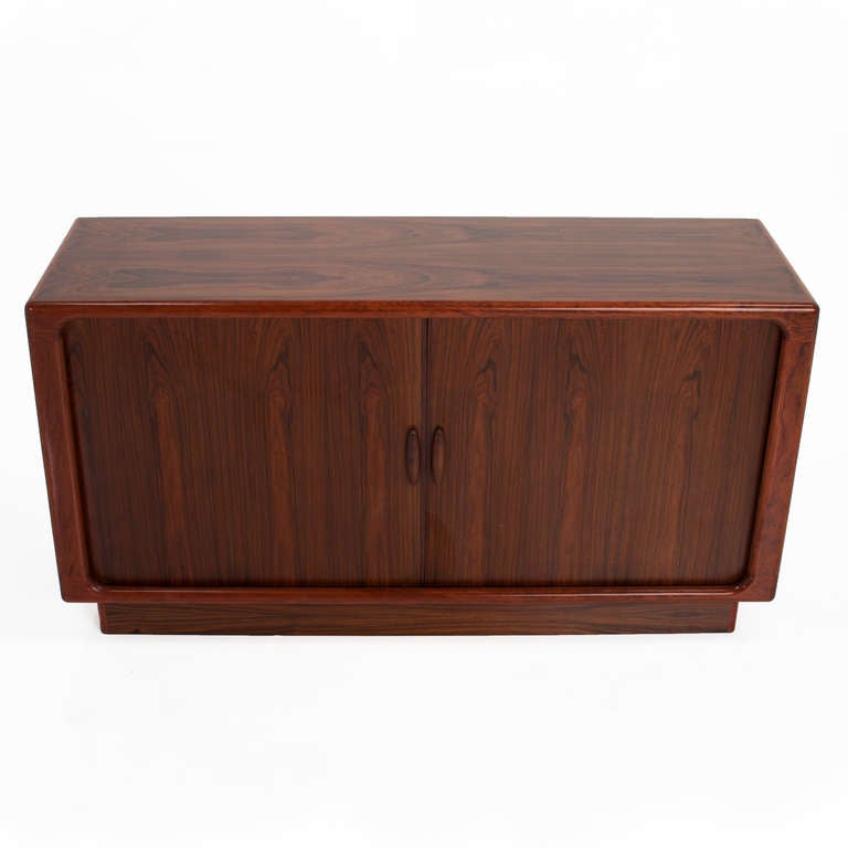 A Danish tambour sideboard or credenza in exotic hardwood with beautiful grain patterns, recessed plinth base, designed by Dyrlund.

Many pieces are stored in our warehouse, so please click on 