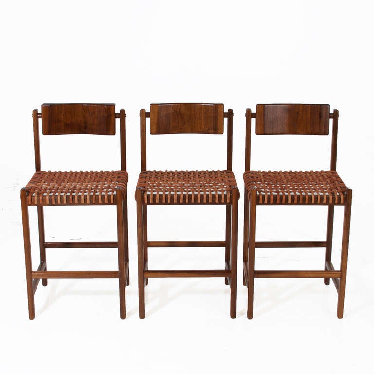 Un tabouret de bar robuste en noyer massif avec une assise en cuir fin et un dossier en noyer massif sculpté qui pivote pour un confort ultime. Le cadre est orné de détails en laiton poli au dos. 

OPTIONS DE BOIS :
Noyer massif, chêne, acajou