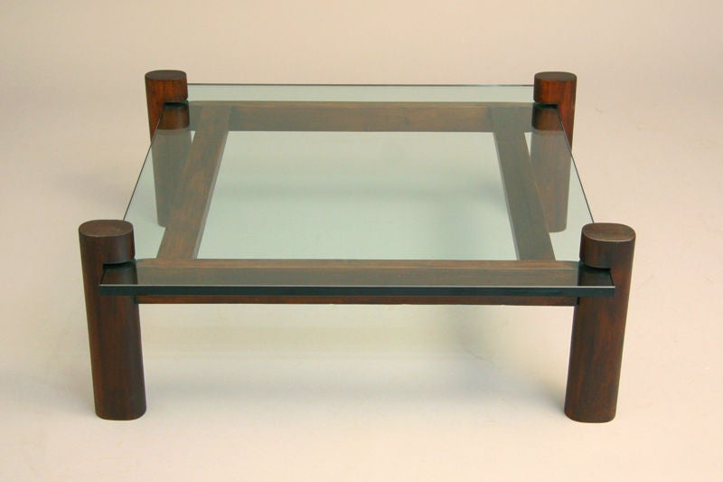 A cantilevered coffee table with solid Brazilian rosewood base and square thick glass top from Brazil. See matching rectangular coffee table from Brazil.
Beautifully refinished with a hand-rubbed French polish. 

Many pieces are stored in our