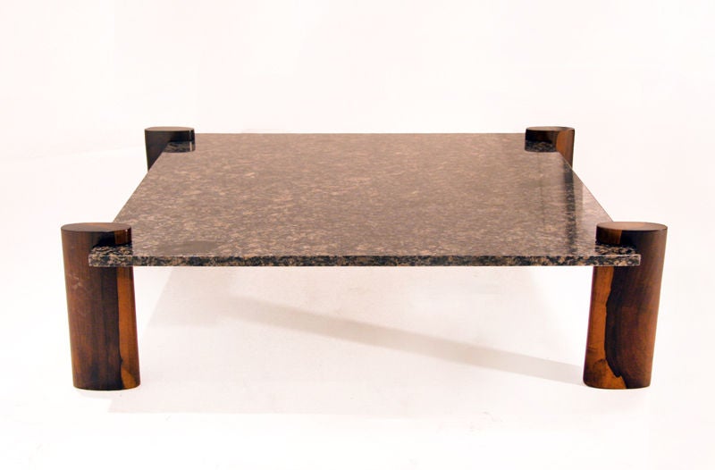 A square coffee table from Brazil with exotic dark grain wood base and a blue freckled granite top inset into the base posts by Celina.

Many pieces are stored in our warehouse, so please click 