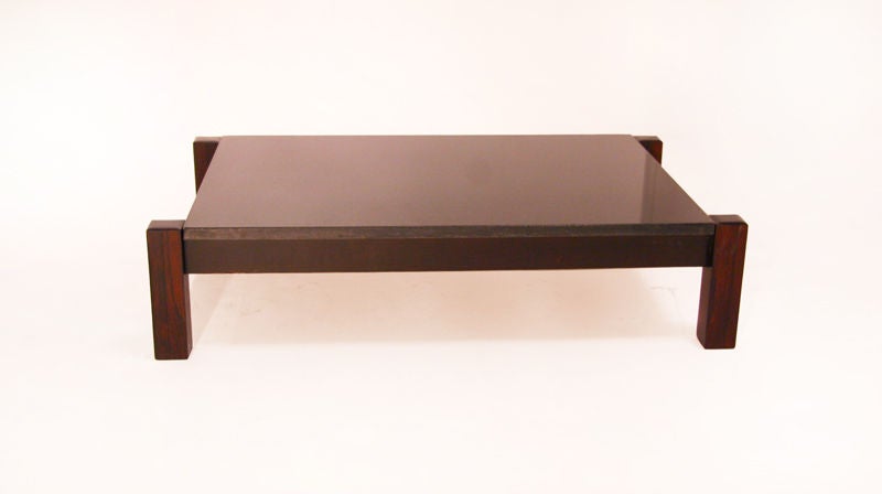 A rectangular coffee table from Brazil with a thick solid rosewood base and a black granite top with a polished finish.

Many pieces are stored in our warehouse, so please click on 