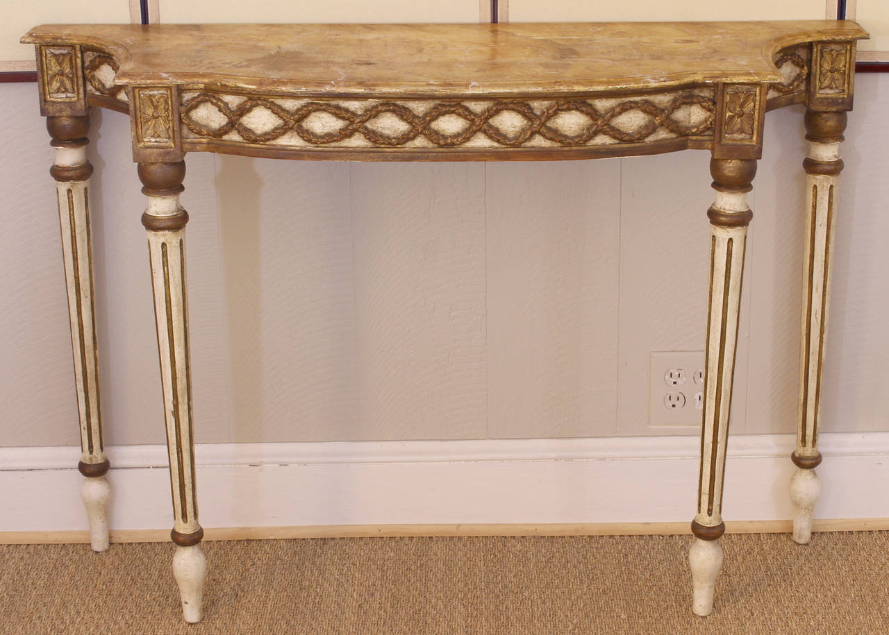 A carved and painted decorated wood console table by the Italian decorative arts manufacturer Palladio with faux marble top.