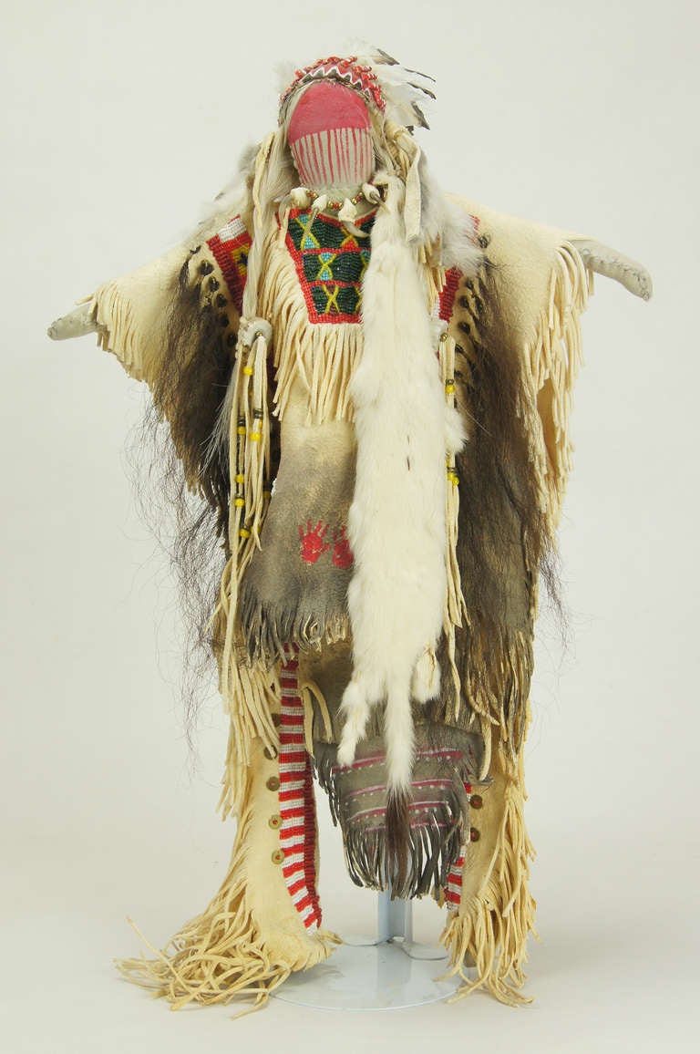 An elaborately detailed full war dress costume of a Souix chief. The signed and numbered doll displays exquisite beadwork on the doe skin shirt and leggings as well as such authentic touches as real pelts, a claw necklace, exotic feathers and tufts