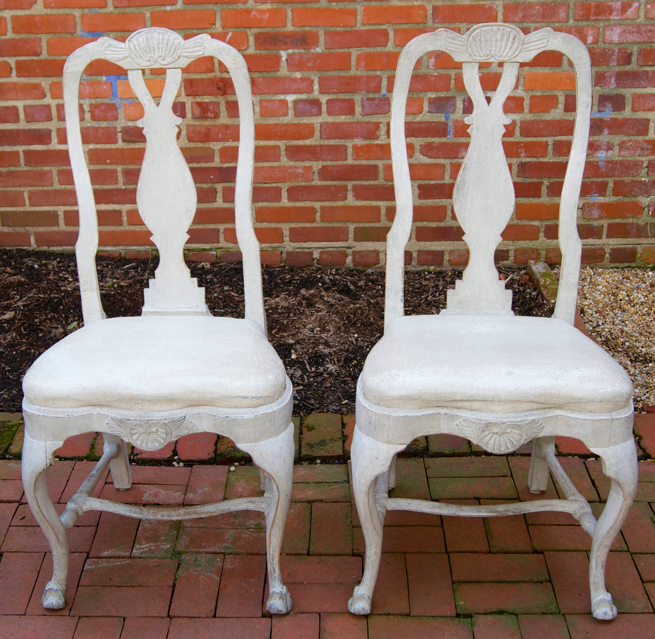 A very elegant pair of mid-18th century carved and painted Swedish side chairs upholstered in a soft white leather.