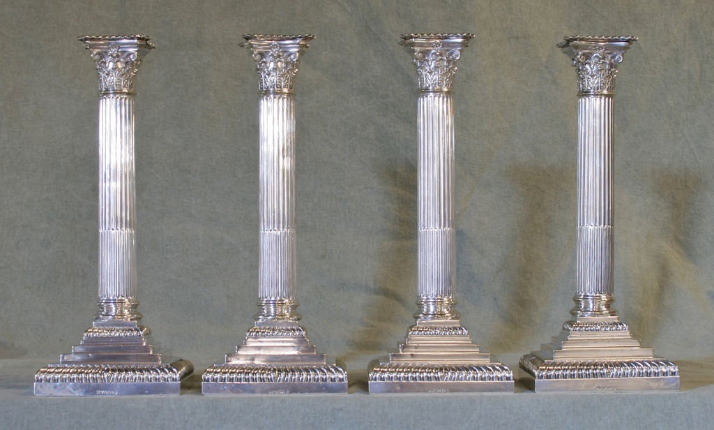 A fabulous set of four large sterling silver corinthian column candlesticks each displaying a complete set of English hallmarks.