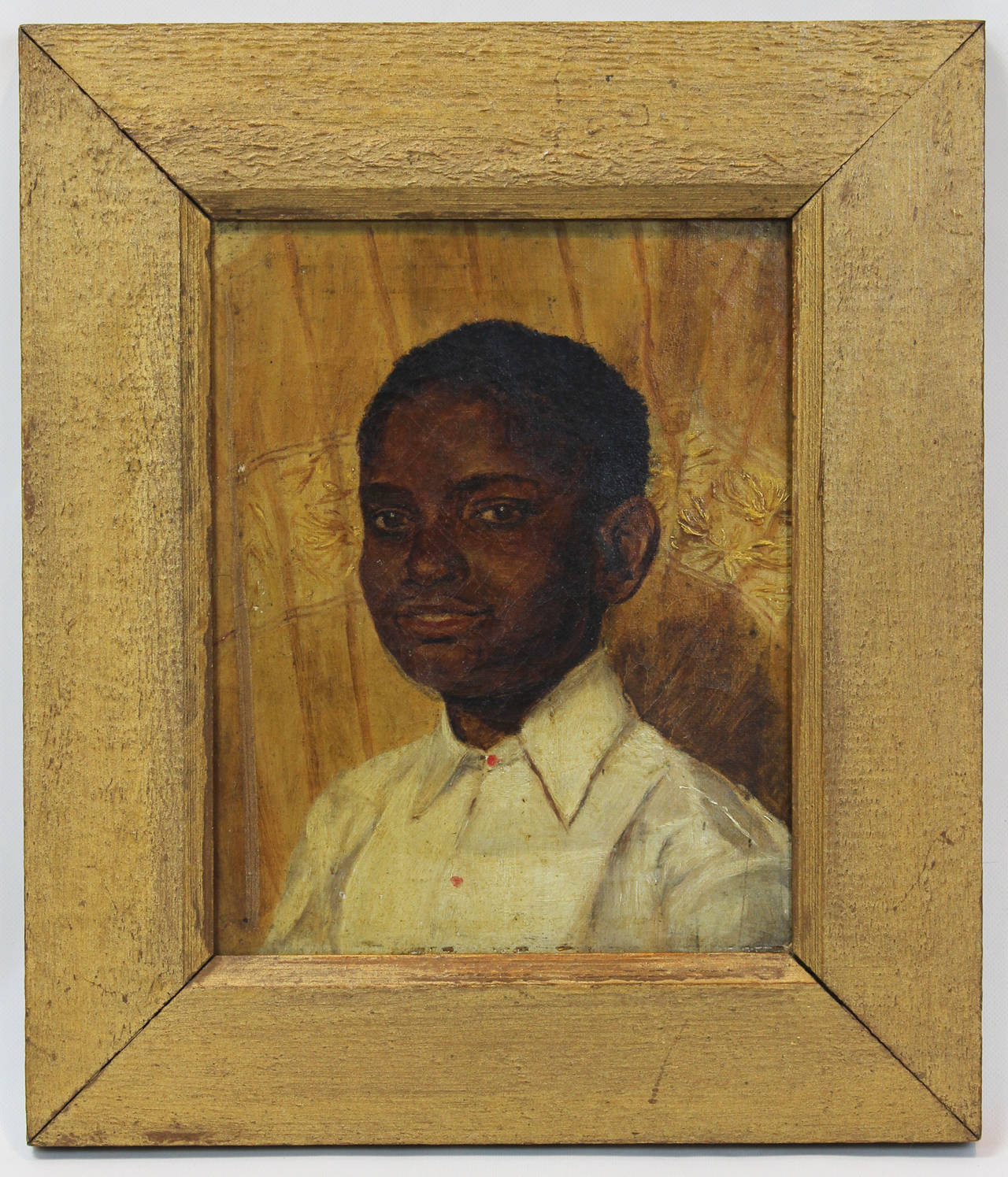 Late 19th century English oil on canvas portrait of a young black man wearing a white shirt with brilliant red buttons in it's original painted frame.