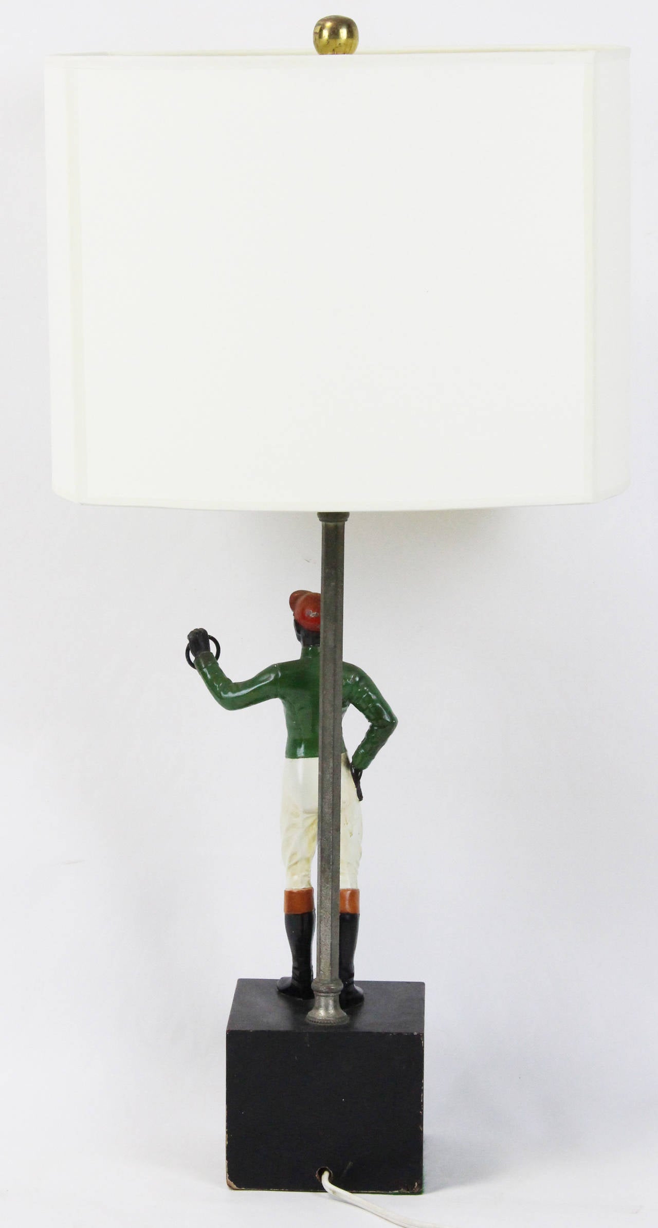 A very charming and high quality painted cast metal jockey standing on a wooden base fashioned into a lamp.