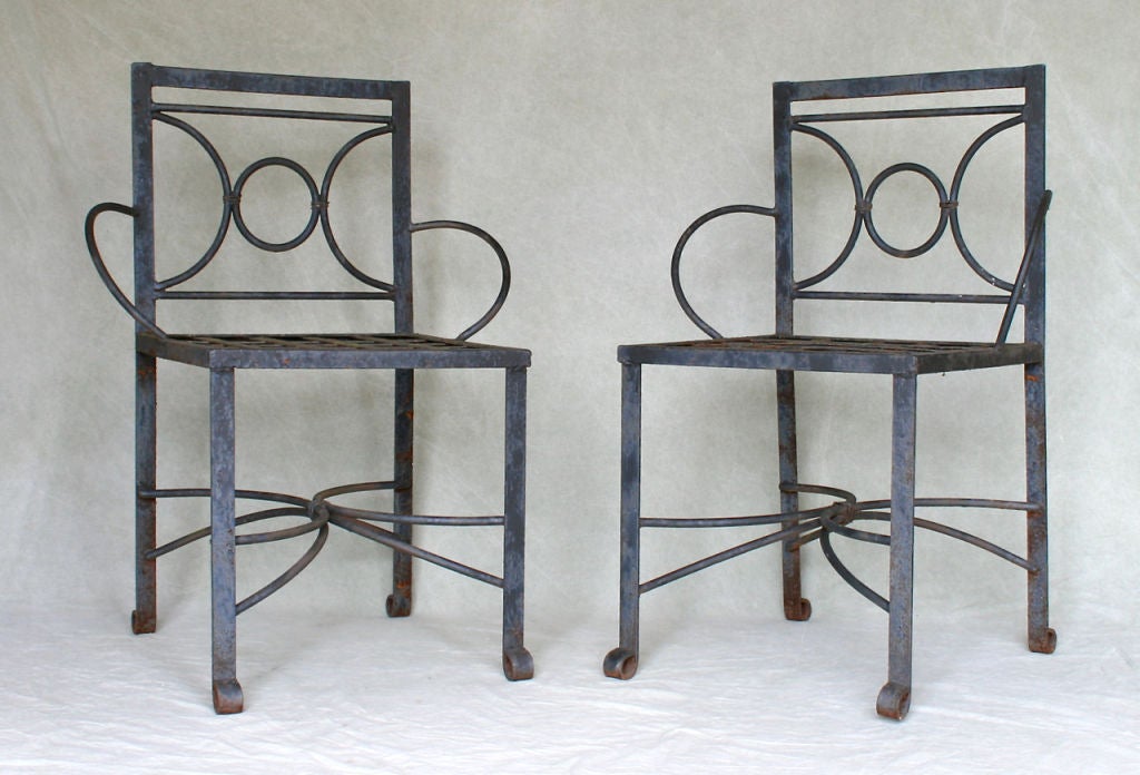 A bold and elegant pair of hand wrought iron armchairs with their original, as-found patina.